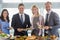 Portrait of business colleagues serving themselves at buffet lunch