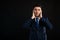 Portrait of business man wearing blue business suit and tie covering ears like deaf gesture