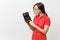 Portrait of business teacher or accountant woman in red shirt, glasses holding calculator in hands on white