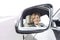 Portrait of businessman reflecting in side-view mirror of car