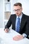 Portrait of businessman sitting at the desk in office workplace