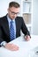 Portrait of businessman sitting at the desk in office workplace