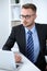 Portrait of businessman sitting at the desk in office workplace