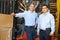 Portrait Of Businessmen With Fork Lift Truck In Warehouse