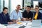 Portrait of businesspeople sitting at desk during meeting