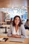 Portrait Of Businesswoman At Desk In Modern Office Work Space With Closed Laptop