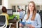 Portrait Of Businesswoman Studying Report In Busy Modern Office