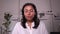 Portrait of businesswoman talking in front of screen and sitting at table in modern office spbi.