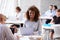 Portrait Of Businesswoman Working On Laptop In Busy Office