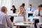 Portrait Of Businesswoman Working On Laptop In Busy Office