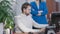 Portrait of busy Caucasian man looking through documents with unrecognizable woman standing with crossed hands at