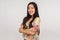 Portrait of calm friendly kind asian girl in summer blouse standing with crossed hands and looking at camera with toothy smile