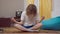 Portrait of calm young retro man with long curly hair falling asleep sitting in lotus pose indoors. 1990s guy practicing