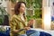 Portrait of calm young woman in casual wear sitting in Lotus pose, doing some meditation at home