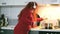 Portrait of a carefree curly woman who cooks in the kitchen and sings. Pretty cheerful red-haired woman listens to music