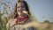 Portrait of carefree plump woman in summer dress necklace looking at the camera through the ears of wheat smiling