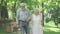 Portrait of carefree senior husband and wife strolling in sunny park and talking. Happy old Caucasian man and woman