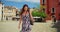 Portrait of carefree smiling young Latina woman twirling on a Venice street