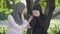 Portrait of caring Muslim woman supporting upset friend outdoors. Young supportive lady calming crying woman in