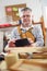 Portrait of carpenter sitting at his workshop use a digital tablet to take pictures