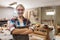 Portrait carpenter woman smiling looking at camera standing at woodwork. factory industry furniture.