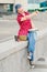 Portrait of a casual cute and young girl with blue hair in jeans in urban summer drawing or writing