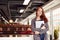 Portrait Of Casually Dressed Young Businesswoman Standing In Modern Open Plan Workplace