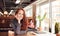 Portrait Of Casually Dressed Young Businesswoman Working At Desk In Modern Open Plan Workplace