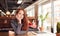 Portrait Of Casually Dressed Young Businesswoman Working At Desk In Modern Open Plan Workplace