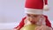 portrait caucasian baby kid toddler Santa costume red hat playing golden balloon
