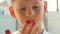 Portrait of a Caucasian boy 6-8 years old eating juicy raspberries from his fingers. child enjoys ripe berry. Theme child in summe