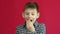 Portrait of a Caucasian boy 7-8 years old pulling out his milk swinging tooth. The child suffers from a toothache and removes his