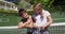 Portrait of caucasian brother and sister smiling together while standing at at tennis court on