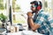 Portrait of caucasian businessman sitting at working desk with computer smiling and listening to music with headset at home office