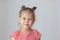 Portrait of caucasian calm little girl of five years old on grey background looking at camera