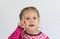 Portrait of caucasian child of three years old holding finger to show number one or telling importance looking at camera on the