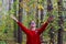 Portrait of a caucasian cute girl in a red sweater and jeans throws up colorful autumn leaves. The idea of happiness