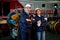 Portrait of Caucasian factory worker or technician stand with arm crossed beside Asian factory woman and look at camera by stand