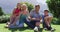 Portrait of caucasian family smiling together while sitting in the garden on a bright sunny day