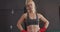 Portrait of caucasian female boxer with hands on hips standing at the gym