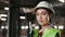 Portrait of a Caucasian female forklift operator, dressed in a green uniform and a hard hat, in a retail warehouse full