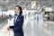 Portrait of Caucasian flight attendant standing in airport terminal. Attractive beautiful cabin crew or air hostess woman smiling