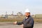 Portrait of caucasian foreman in helmet standing in construction site background.