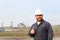 Portrait of caucasian foreman with thumbs up standing in construction site background.