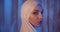 Portrait of a caucasian girl in a white hijab neon light look into the camera look u-turn serious night make-up blue