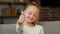 Portrait caucasian happy satisfied blonde girl little positive child kid looking at camera make thumb up like and