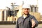 Portrait of caucasian industrial worker with outstretched hand standing near factory,