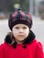 Portrait of caucasian little girl of three age in red coat looking at camera seriously