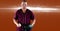 Portrait of caucasian male baseball pitcher holding ball against spot of light on orange background