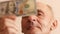Portrait of a Caucasian pensioner 70 years older looking at a 100 dollar bill. Household budget and money of the elderly. Receivin